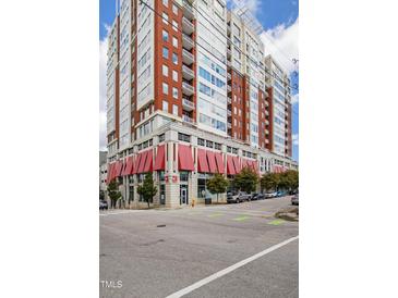 Stunning condominium building featuring red brick accents, balconies, and a retail space with red awnings at 400 W North St # 1204, Raleigh, NC 27603