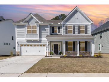 Inviting two-story home featuring a two-car garage, charming front porch, and well-manicured lawn at 4320 Stony Falls Way, Knightdale, NC 27545