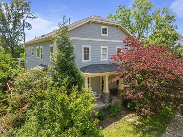 Charming two-story home with a covered front porch and mature landscaping creates great curb appeal at 445 S Greensboro St, Carrboro, NC 27510
