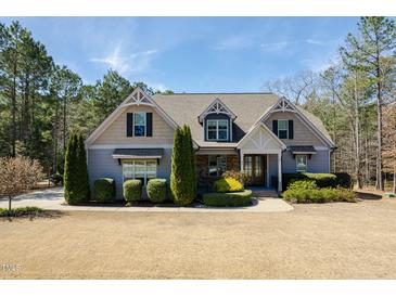 Charming two-story home features beautiful landscaping, a well-manicured lawn, and a welcoming entrance at 45 Carriden Dr, Youngsville, NC 27596