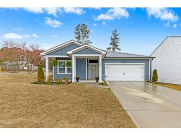Charming one-story home with a manicured lawn and inviting front porch at 501 Campbell Ridge Pl, Wendell, NC 27591