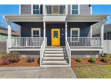 Inviting home featuring a bright yellow front door and a charming white railed porch at 613 Canal St, Durham, NC 27701