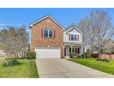Charming two-story home featuring a brick facade, attached garage, and a well-maintained lawn at 6817 Osprey Landing Dr, Wendell, NC 27591