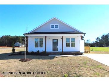 Charming single-story home featuring a welcoming front porch and a well-manicured lawn at 87 Legolas Ct, Middlesex, NC 27557