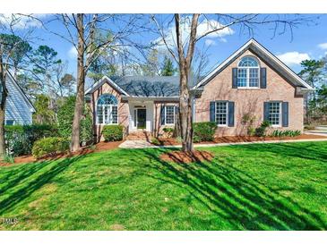 Charming brick home with a well-manicured lawn, mature trees, and inviting curb appeal at 100 Pebble Ridge Farms Ct, Cary, NC 27513