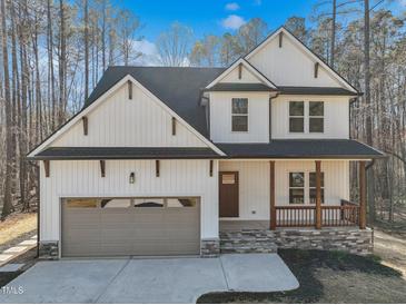 Charming two-story home featuring white siding, a gray roof, and a two car garage at 109 Mohawk Dr, Louisburg, NC 27549