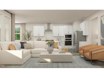 Bright and open living room and kitchen with white cabinets, stainless steel appliances, and stylish decor at 1573 Goldfinch Perch Ln, Knightdale, NC 27545