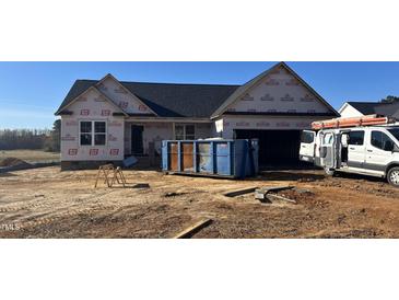 New construction home featuring a two-car garage and covered front porch awaiting finishing touches at 207 N Movado Trl, Kenly, NC 27542