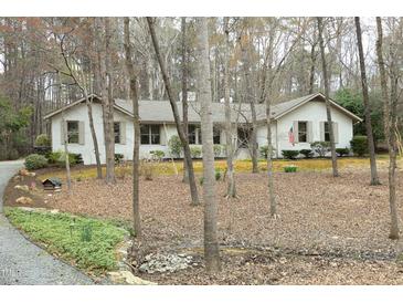 Charming single-story home featuring a painted brick exterior and mature landscaping at 21 Wedgewood Rd, Chapel Hill, NC 27514