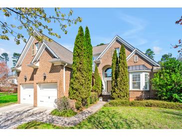 Charming brick home with manicured lawn and two-car garage, offering curb appeal at 4 Teahouse Ct, Durham, NC 27707