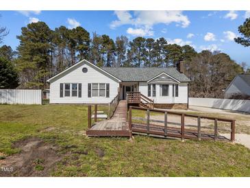 Charming single story home with wooden ramp and white siding against a backdrop of mature trees at 5437 Grasshopper Rd, Raleigh, NC 27610