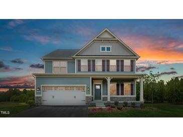Charming two-story home featuring a two-car garage, well-kept lawn, and inviting front porch at 549 Freedom Trail Dr, Willow Springs, NC 27592