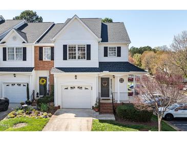 Charming two-story townhome featuring attached garage, black shutters, covered porch, and well-maintained lawn at 5569 Sea Daisy Dr, Raleigh, NC 27606