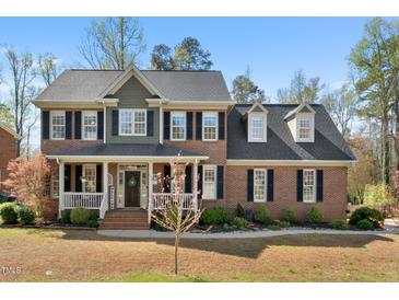 Charming two-story brick home with a welcoming front porch and manicured landscaping at 706 Oldwyck Dr, Fuquay Varina, NC 27526