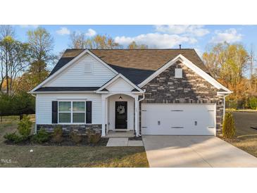 Charming single-Gathering home featuring stone accents, a black front door with wreath, and a well-maintained lawn at 75 Red Crabapple Ct, Clayton, NC 27520