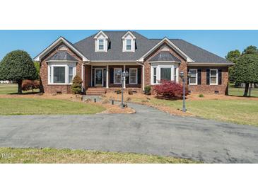 Charming single-Gathering brick home with a landscaped front yard and curved driveway at 1055 Tilghman Rd, Dunn, NC 28334
