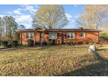 Charming brick home featuring a cozy entrance and well-maintained front yard at 1122 Snow Hill Rd, Durham, NC 27712