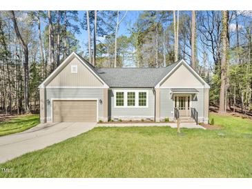 Charming home featuring a neatly kept lawn, attached garage, and beautiful, neutral-toned siding at 133 Mohawk Dr, Louisburg, NC 27549