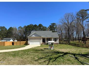 Charming single-story home with a well-manicured lawn, attached garage, and inviting front porch at 495 Cheves Rd # 495, Zebulon, NC 27597