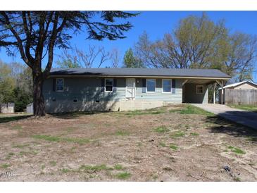 Inviting single-story home with light blue siding and a covered carport, nestled on a spacious lot at 5301 Daleview Dr, Raleigh, NC 27610