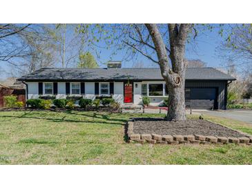 Charming single-story home with a well-maintained lawn, brick accents, and a bright red front door at 761 S Eighth St, Mebane, NC 27302