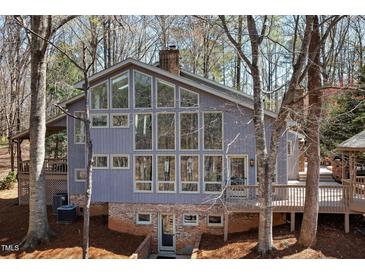 Attractive exterior with large windows and a brick foundation, surrounded by mature trees at 7917 Holly Springs Rd, Raleigh, NC 27606