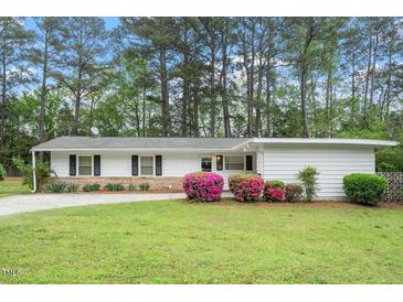 Charming single story home with landscaped front yard and colorful azaleas, offers great curb appeal at 911 Williams Rd, Raleigh, NC 27610