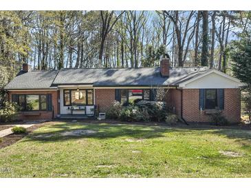 Charming brick home featuring dark shutters, black framed windows and a well maintained lawn at 105 Blanchard St, Fuquay Varina, NC 27526