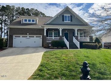 Charming two-story brick home with a well-manicured lawn and attached two car garage at 115 Pecan Harvest Dr, Garner, NC 27529