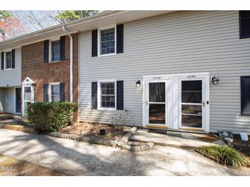 Inviting townhouse exteriors with well-maintained yards and brick and vinyl siding at 1248 Jamestown Ct, Cary, NC 27511