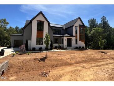 Stunning new construction home boasts a modern design and beautiful curb appeal with large windows and gray accents at 170 Cherry Bark Dr, Youngsville, NC 27596