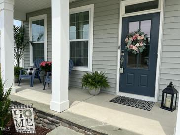 Charming front porch with gray siding, blue door with wreath, and inviting seating at 190 Salem Village Dr, Fuquay Varina, NC 27526