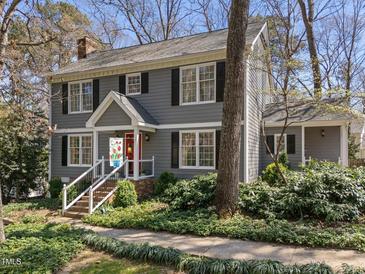 Charming two-story home with gray siding, black shutters, front porch, and landscaped yard at 2005 Bridgeport Dr, Raleigh, NC 27615