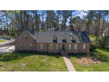 Charming brick home with dormer windows and a well-manicured front yard with mature tree coverage at 209 Ashmore Ln, Rocky Mount, NC 27804