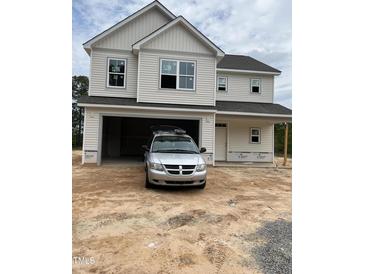 Two-story home featuring an attached garage and light siding complemented by crisp white trim at 228 Dove Rd, Cameron, NC 28326