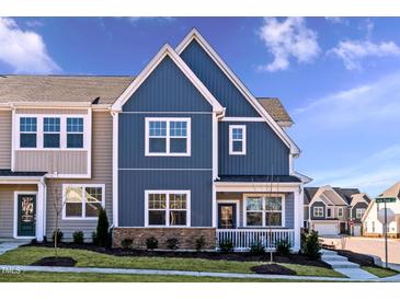Charming townhome showcasing blue siding, white trim, stone accents, and a welcoming front porch at 2469 Englemann Dr # 366, New Hill, NC 27562