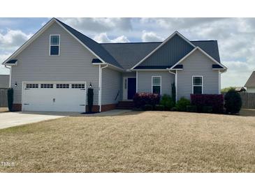 Charming one-story home featuring a two-car garage, landscaped yard and inviting entrance at 30 Wheat Dr, Angier, NC 27501