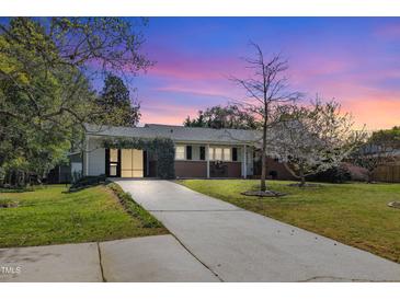 Charming single-story home boasts a well-manicured lawn and inviting brick facade, creating a warm and welcoming curb appeal at 300 Lakeside Dr, Garner, NC 27529
