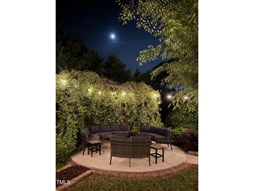 Beautiful patio with lovely outdoor seating, plants and string lights under a full moon at 300 Lakeside Dr, Garner, NC 27529