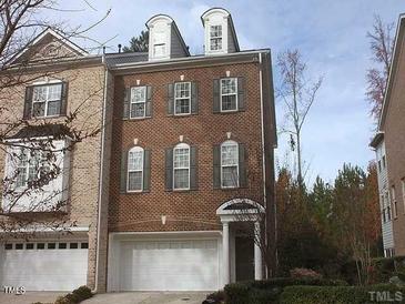 Charming brick townhouse featuring multiple windows and a two-car garage at 335 Bridgegate Dr, Cary, NC 27519