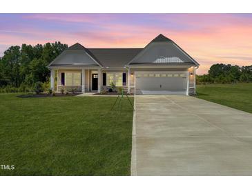Charming single-Gathering home featuring a well-manicured lawn, long driveway, and attached two-car garage at 4013 Kingcraig Ln, Zebulon, NC 27597