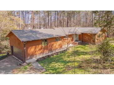 Charming single-story home with a metal roof, wood siding, and an attached garage at 501 Hiddenbrook Dr, Durham, NC 27703