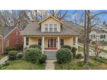 Charming yellow two-story home with a welcoming front porch and well-manicured landscaping at 529 Hillcrest Ave, Burlington, NC 27215