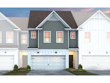 Charming townhome showcasing a two-car garage, neutral siding and a welcoming front entrance at 6002 Enclosure Way, Durham, NC 27703