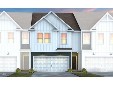 Beautiful townhome exterior showcasing a modern design, attached garage, and welcoming curb appeal at 6004 Enclosure Way, Durham, NC 27703