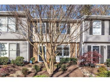 Charming townhome featuring tan siding, brick accents, and neatly landscaped front yard at 7727 Ohmann Ct, Raleigh, NC 27615