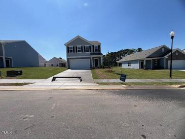 Charming two-story home featuring a manicured lawn and classic architectural details at 837 Kenyon Spring Dr, Zebulon, NC 27597
