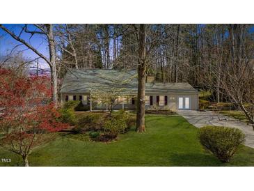 Charming single-story home featuring well-manicured lawn and beautiful landscaping at 901 Emory Ln, Raleigh, NC 27609