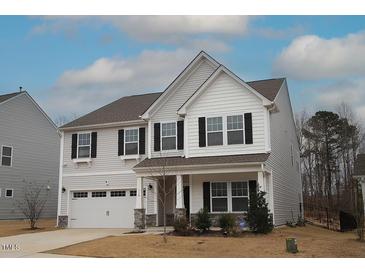 Charming two-story home featuring a covered porch, two-car garage, and black window shutters at 110 Manor Stone Dr, Clayton, NC 27527