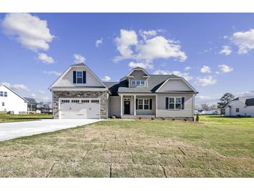 Charming home featuring stone accents, a two-car garage, and a well-manicured lawn at 115 S Harper Faith Way, Benson, NC 27504